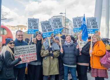 London, UK. 18th January 2023. Striking nurses with placards and banners, demonstrating outside the main entrance of University College Hospital, London, in protest to government cuts and unfair pay.