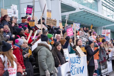 London, UK. 18th January 2023. Striking nurses with placards and banners, demonstrating outside the main entrance of University College Hospital, London, in protest to government cuts and unfair pay.