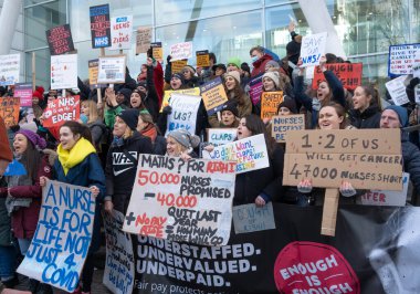 London, UK. 18th January 2023. Striking nurses with placards and banners, demonstrating outside the main entrance of University College Hospital, London, in protest to government cuts and unfair pay.