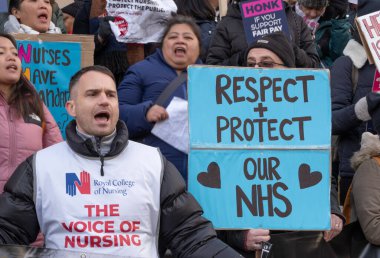 London, UK. 18th January 2023. Striking nurses with placards and banners, demonstrating outside the main entrance of University College Hospital, London, in protest to government cuts and unfair pay.