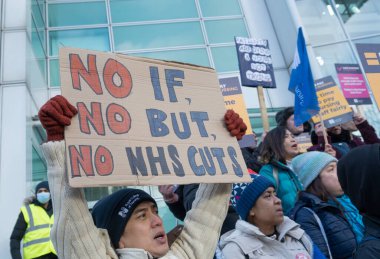 London, UK. 18th January 2023. Striking nurses with placards and banners, demonstrating outside the main entrance of University College Hospital, London, in protest to government cuts and unfair pay.