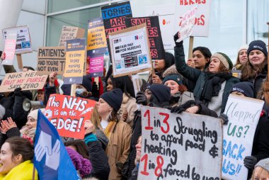 London, UK. 18th January 2023. Striking nurses with placards and banners, demonstrating outside the main entrance of University College Hospital, London, in protest to government cuts and unfair pay.