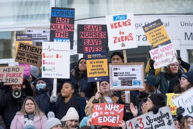 London, UK. 18th January 2023. Striking nurses with placards and banners, demonstrating outside the main entrance of University College Hospital, London, in protest to government cuts and unfair pay.