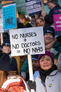 London, UK. 18th January 2023. Striking nurses with placards and banners, demonstrating outside the main entrance of University College Hospital, London, in protest to government cuts and unfair pay.
