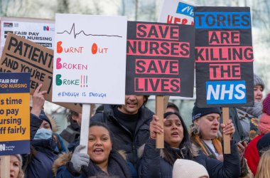 London, UK. 18th January 2023. Striking nurses with placards and banners, demonstrating outside the main entrance of University College Hospital, London, in protest to government cuts and unfair pay.