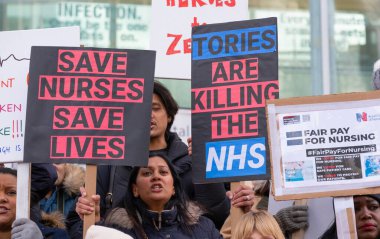 London, UK. 18th January 2023. Striking nurses with placards and banners, demonstrating outside the main entrance of University College Hospital, London, in protest to government cuts and unfair pay.
