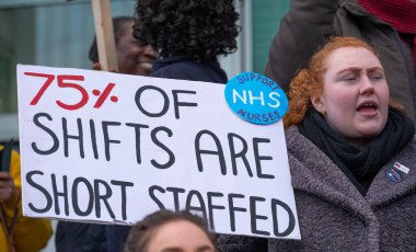 London, UK. 18th January 2023. Striking nurses holding placards and signs, demonstrating outside the main entrance of University College Hospital, London, in protest to government cuts and unfair pay.