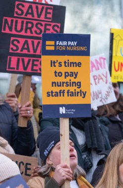 London, UK. 18th January 2023. Striking nurses holding placards and signs, demonstrating outside the main entrance of University College Hospital, London, in protest to government cuts and unfair pay.