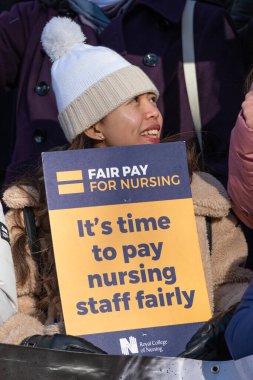 London, UK. 18th January 2023. Striking nurses holding placards and signs, demonstrating outside the main entrance of University College Hospital, London, in protest to government cuts and unfair pay.