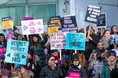 Striking nurses with placards and banners, demonstrating outside the main entrance of University College Hospital, London, in protest to government cuts and unfair pay.