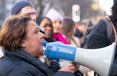 Striking nurses with placards and banners, demonstrating outside the main entrance of University College Hospital, London, in protest to government cuts and unfair pay.