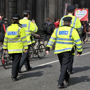 Londra, İngiltere. 12 Mayıs 2012. Metropolitan polis memurları, İşgal Hareketi protestocuları etrafında herhangi bir suç işlenmesini önlemek için, İngiltere Bankası binası önünde bir kordon oluşturur..