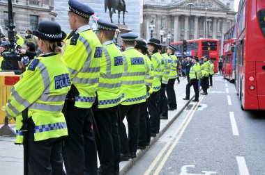 Londra, İngiltere. 12 Mayıs 2012. Metropolitan polis memurları, İşgal Hareketi protestocuları etrafında herhangi bir suç işlenmesini önlemek için, İngiltere Bankası binası önünde bir kordon oluşturur..