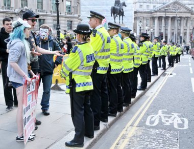 Londra, İngiltere. 12 Mayıs 2012. Metropolitan polis memurları, İşgal Hareketi protestocuları etrafında herhangi bir suç işlenmesini önlemek için, İngiltere Bankası binası önünde bir kordon oluşturur..