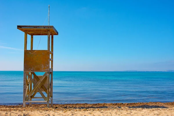 stock image Lifeguard tower on a sandy beach without people, with a clear blue sky looking down on the Mediterranean Sea.