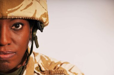 İngiliz Ordusu çöl kamuflaj üniforması giyen siyah kadın askerin yarım portresi..