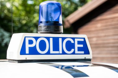 Devriye arabasının çatısında mavi ışıklar olan polis işareti..