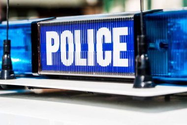 Devriye arabasının çatısında mavi ışıklar olan polis işareti..