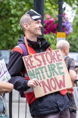 Londra, İngiltere. 22 Haziran 2024. Çevre protestocusu, Londra 'da düzenlenen protesto gösterisinde, doğa ve iklim acil durumları hakkında acil siyasi eylem çağrısında bulundu..