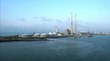 Dublin, İrlanda. 6 Eylül 2024. Poolbeg Üretim İstasyonu 'nun açık mavi gökyüzüne doğru yavaş hareket eden hava görüntüsü. İstasyon Dublin Limanı 'nın güney kıyısındaki Ringsend' de yer almaktadır..