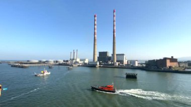 Dublin, İrlanda. 8 Eylül 2024. Sabahın erken saatlerindeki mavi gökyüzüne karşı Poolbeg Üretim İstasyonu 'nun yavaş hareket eden hava görüntüsü. İstasyon Dublin Limanı 'nın güney kıyısındaki Ringsend' de yer almaktadır..
