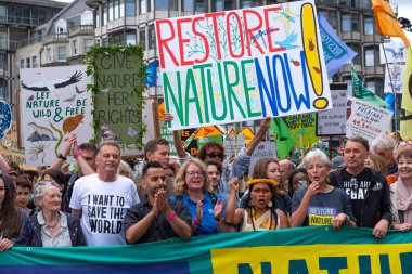 Londra, İngiltere. 22 Haziran 2024. Doğayı Yenile 'de pankartı olan çevre protestocuları Londra' da protesto gösterileri düzenleyerek, doğa ve iklim acil durumları hakkında acil siyasi eylem çağrısında bulundular..