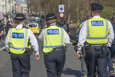 Londra, İngiltere. 26 Mart 2022. Londra 'nın merkezinde düzenlenen Ukrayna yanlısı gösteri mitinginde protestocuları izlemek ve onlara eşlik etmek üzere görevli Metropolitan polis memurları.