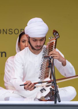 London, UK. 6th April 2024. Sikh musician performing on the dilruba at the Vaisakhi Festival in Trafalgar Square, London, the event celebrating Sikh culture and the traditional spring harvest. clipart