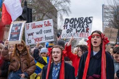 Londra, İngiltere. 22 Şubat 2025. Bayraklı ve işaretli protestocular Rusya 'nın çıkışında! Londra 'daki Holland Park' ta UKRAINE mitingi ve gösterisiyle dayanışma. Rusya 'nın yasadışı Ukrayna işgalinin üçüncü yıldönümü münasebetiyle protesto.