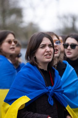 Londra, İngiltere. 22 Şubat 2025. Ukrayna bayrağı taşıyan protestocular Rusya 'nın çıkışında! Holland Park, Londra 'daki UKRAINE mitinginde dayanışma. Rusya 'nın yasadışı Ukrayna işgalinin üçüncü yıldönümü münasebetiyle protesto.