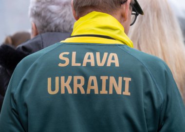 Londra, İngiltere. 22 Şubat 2025. SLAVA UKRAINI 'li protestocu Rusya' nın çıkışında gömleğine basmış! Holland Park, Londra 'daki UKRAINE mitinginde dayanışma. Rusya 'nın yasadışı Ukrayna işgalinin üçüncü yıldönümü münasebetiyle protesto.