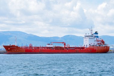 Cebelitarık. 15 Nisan 2025. Portekiz petrol tankeri Herkül Gökyüzü, Gibraltar Limanı 'ndaki iskelenin yanında demirlemiş ve arka planda İspanyol Sierra Bermeja sıradağları bulunmaktadır..
