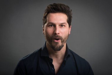 Sıradan bir adam karanlık arka planda yakın plan portresi çizer. Şaşırtıcı ifade..