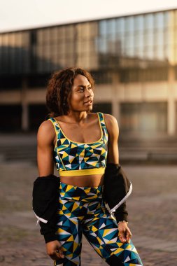 Güneşli bir günde gülümseyen siyah Afrikalı spor kadın portresi..