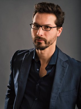 Kendine güvenen zarif bir adam karanlık arka planda portreyi kapatır..