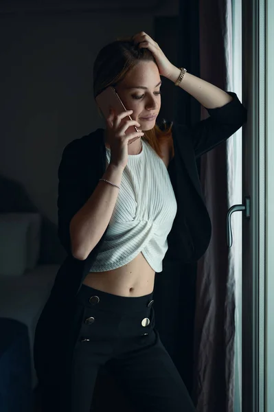 窓の外の電話で話してる若い女性 — ストック写真
