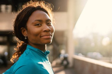 Güneşli bir günde gülümseyen siyah Afrikalı spor kadın portresi..