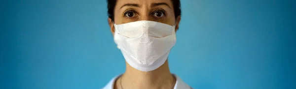医師は コロナウイルスから顔を保護マスクを着用 医療スタッフ予防用具 コピースペースと青の背景を持つパノラマバナー — ストック写真