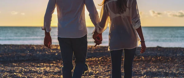 ロマンチックなカップルが手を取り合い 日差しの中でビーチを歩く — ストック写真