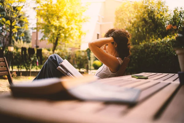 庭の外で本を読んでいる中年の女性 本物のライフスタイル — ストック写真