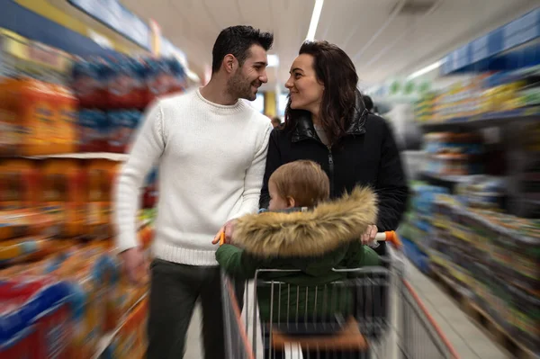 一个快乐的家庭 孩子和购物车一起在超市里散步 放大效果 — 图库照片