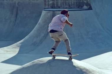 Kaykaycı portresi kaykay parkında kayıyor. Gün batımı ışığı, yaşam tarzı.