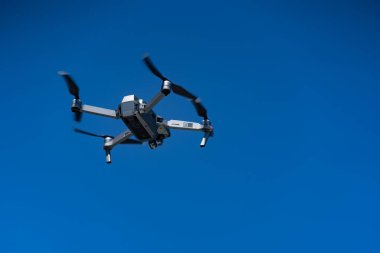 MENORCA, İspanya - Temmuz 2019: Dji Mavic Pro Drone mavi gökyüzüne karşı uçuyor.