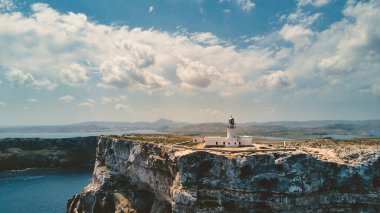 Cape Cavalleria Lighthouse ile kayalık kıyı şeridinin panoramik hava manzarası. Menorca, İspanya 'ya ait Akdeniz' de bulunan Balear Adalarından biri..