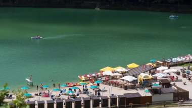 Lavarone Gölü 'nün güneşli bir gününde turistlerin tadını çıkarması. Burası, İtalya 'nın Trentino Alto Adige bölgesindeki gölüyle ünlüdür.. 