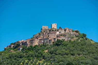 Roccastrada village against blue sky. Tuscany, Italy. clipart