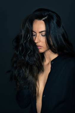 Karanlık arka planda yoğun bir şekilde güzel bir kadın stüdyo resmi..