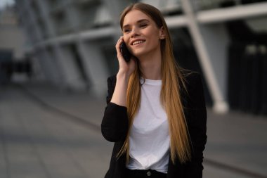 Çekici genç iş kadını portresi açık havada telefonda konuşuyor. Yaşam tarzı resmi.