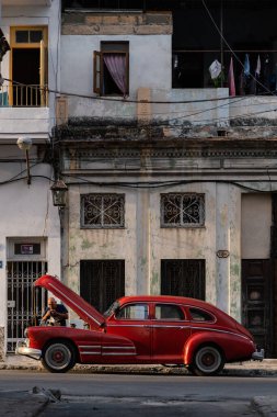 HAVANA, CUBA - Mart 2019: Eski klasik Amerikan arabasını tamir eden adamla sokak manzarası.