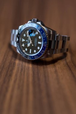 BOLOGNA, İtalya - 2018 ARALIK Rolex GMT Master II ahşap masaya bakın. Rolex SA, 1905 yılında İngiltere 'nin başkenti Londra' da kurulmuş İsviçreli lüks bir saatçidir. İllüstrasyon Editörü.